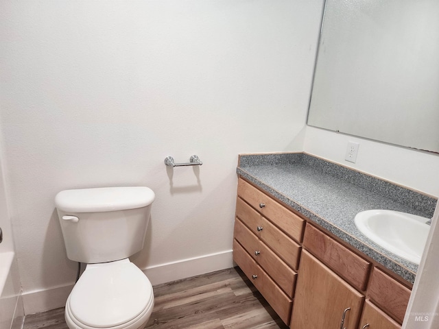 bathroom featuring toilet, vanity, and hardwood / wood-style floors