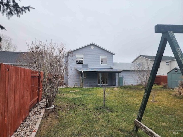 rear view of house featuring a yard