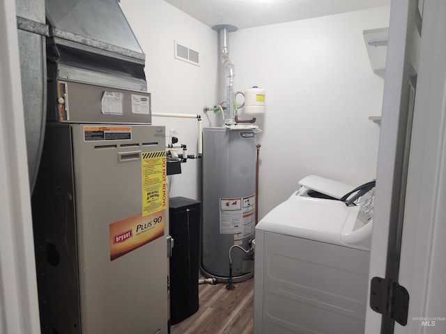 utilities with washer and dryer, heating unit, and gas water heater