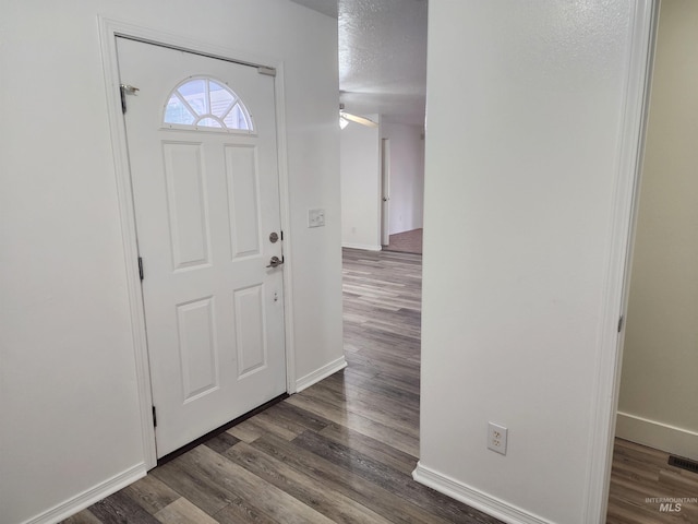 foyer entrance featuring dark hardwood / wood-style flooring and a textured ceiling