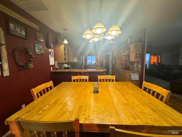 dining space featuring a notable chandelier and lofted ceiling