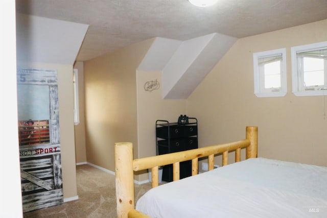 carpeted bedroom with a textured ceiling and vaulted ceiling