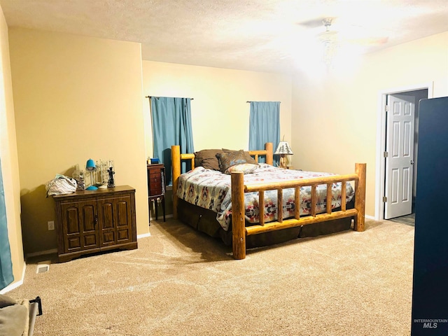 carpeted bedroom with ceiling fan and a textured ceiling