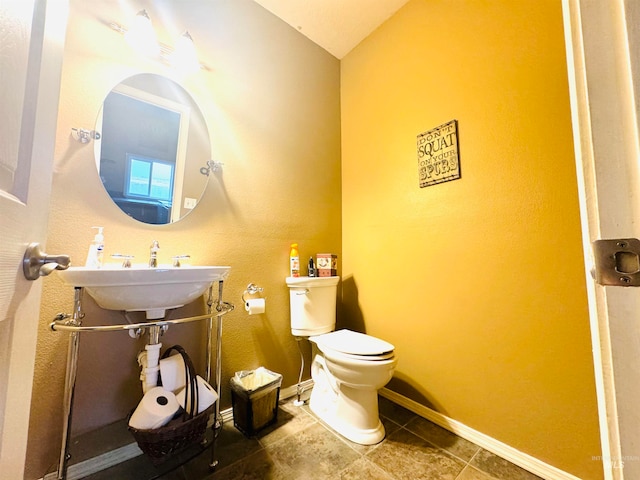 bathroom with vaulted ceiling, sink, and toilet