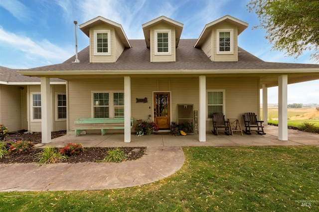 back of property featuring covered porch and a yard