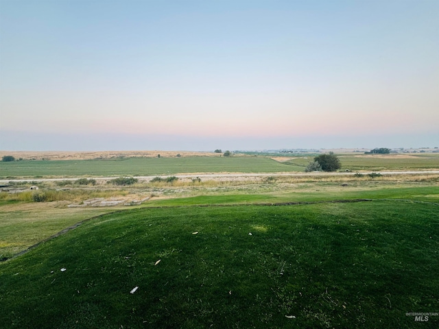 exterior space featuring a rural view and a yard