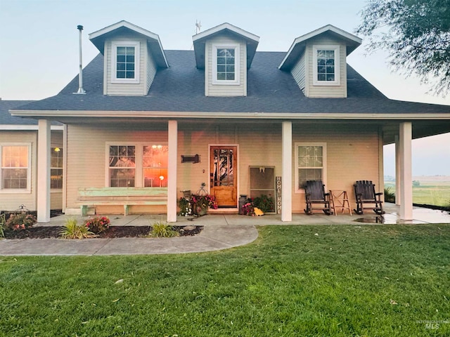 back of house featuring a lawn and covered porch