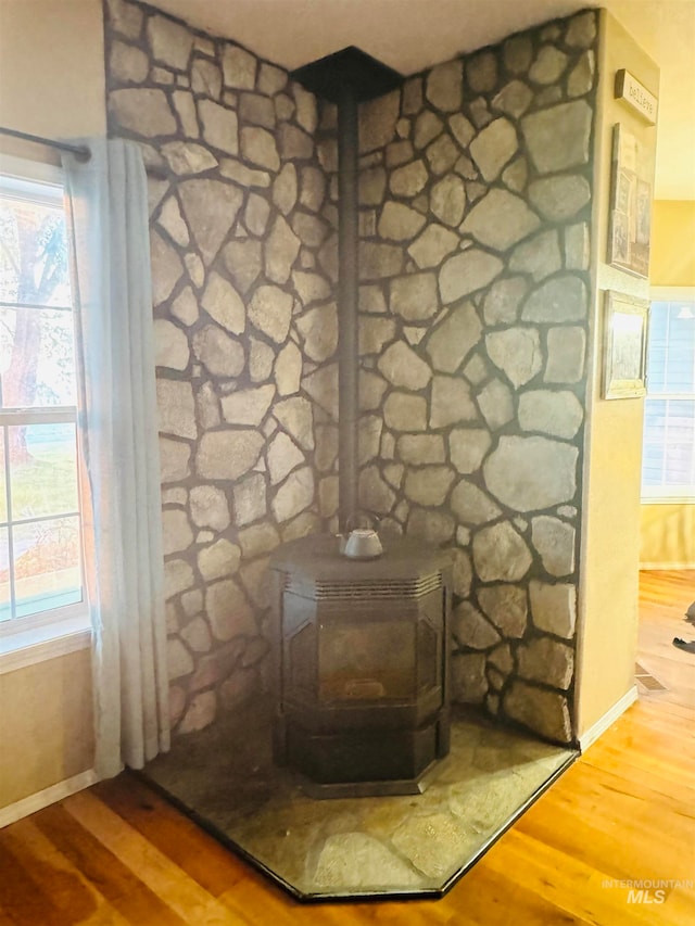 interior details featuring hardwood / wood-style floors and a wood stove