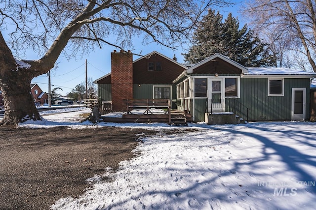 snow covered property featuring a sunroom