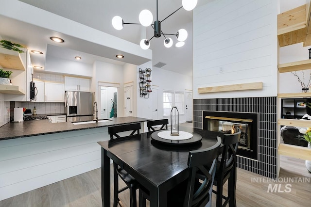 8079 W Beckton Ln, Garden City, ID 83714 - dining space with light wood-type flooring, a fireplace, and a chandelier