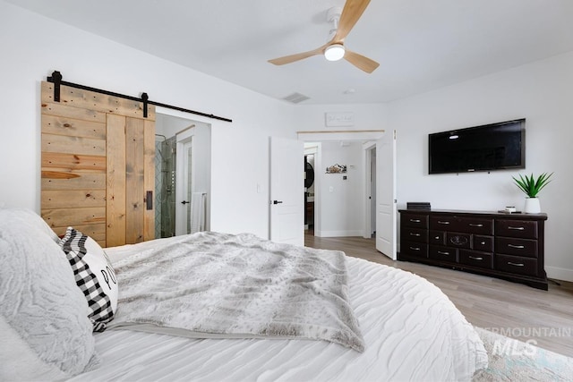 8079 W Beckton Ln, Garden City, ID 83714 - bedroom featuring a barn door, wood finished floors, ceiling fan, and baseboards