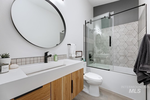 8079 W Beckton Ln, Garden City, ID 83714 - bathroom featuring toilet, wood finished floors, vanity, and combined bath / shower with glass door