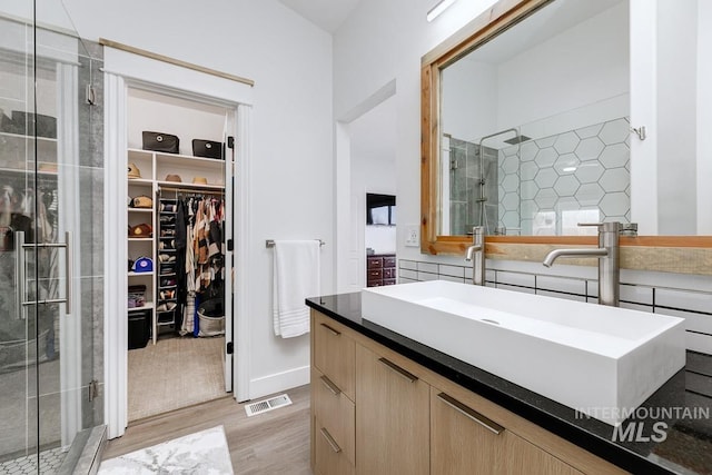 8079 W Beckton Ln, Garden City, ID 83714 - bathroom with wood finished floors, a stall shower, a walk in closet, and vanity