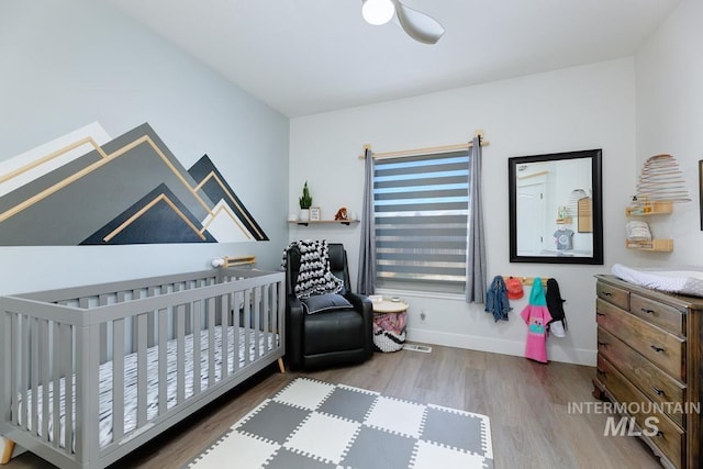 8079 W Beckton Ln, Garden City, ID 83714 - bedroom with wood finished floors, a crib, baseboards, and ceiling fan