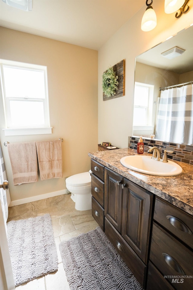 bathroom featuring tasteful backsplash, toilet, visible vents, baseboards, and vanity