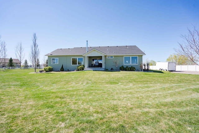 view of front of property featuring a front lawn and fence
