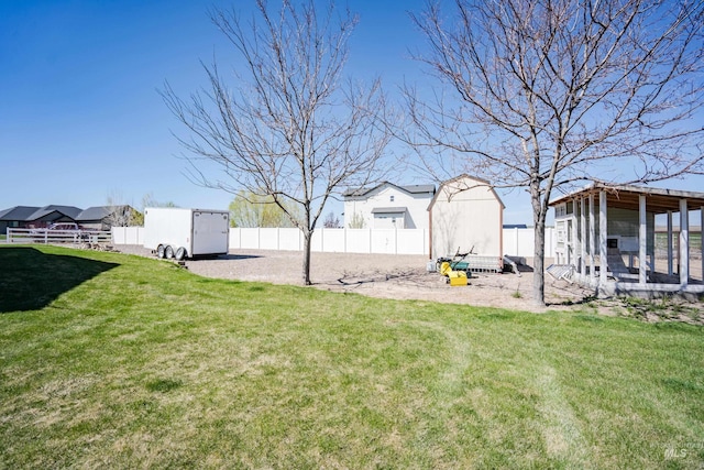 view of yard with a fenced backyard, an outbuilding, and exterior structure