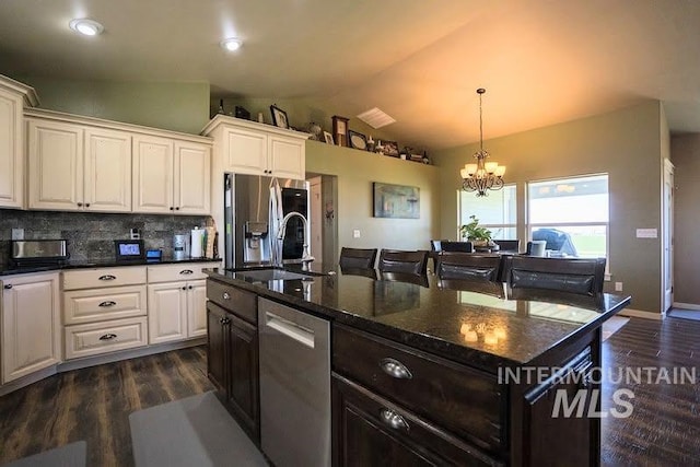 kitchen featuring stainless steel appliances, vaulted ceiling, dark wood-style floors, and a chandelier