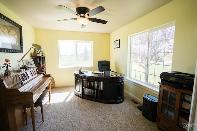 carpeted home office featuring visible vents, baseboards, and ceiling fan