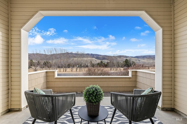 balcony featuring a mountain view, a patio, and an outdoor hangout area