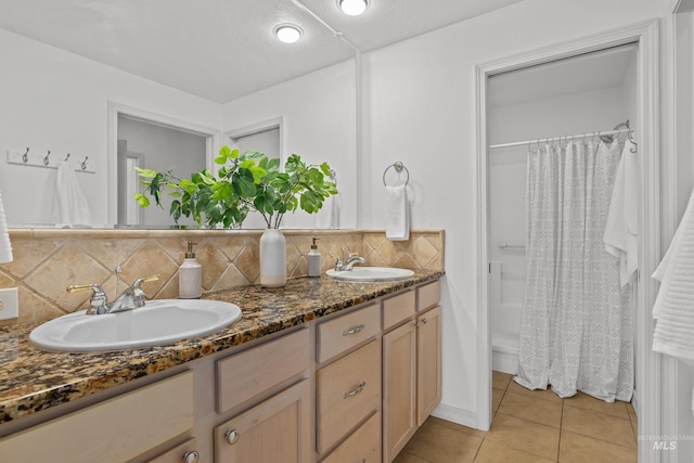 full bathroom featuring tile patterned flooring, a sink, decorative backsplash, and double vanity