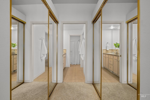 corridor with light colored carpet and light tile patterned floors