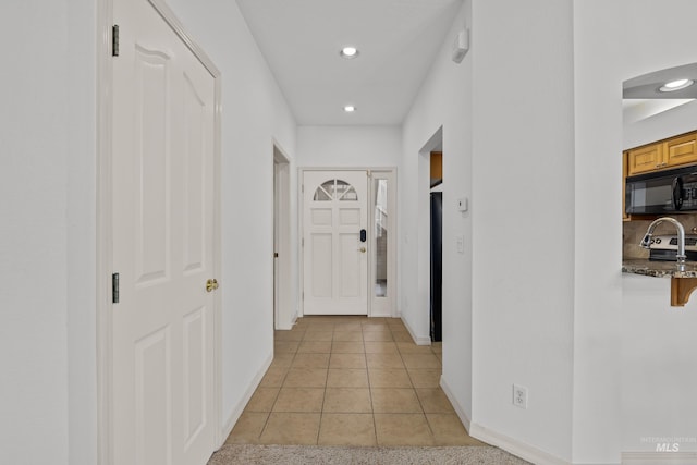 hall with light tile patterned floors, recessed lighting, and baseboards