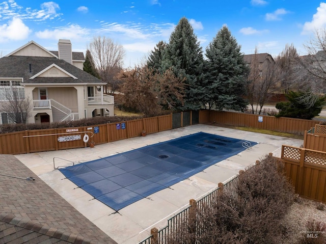 pool with a patio area and fence