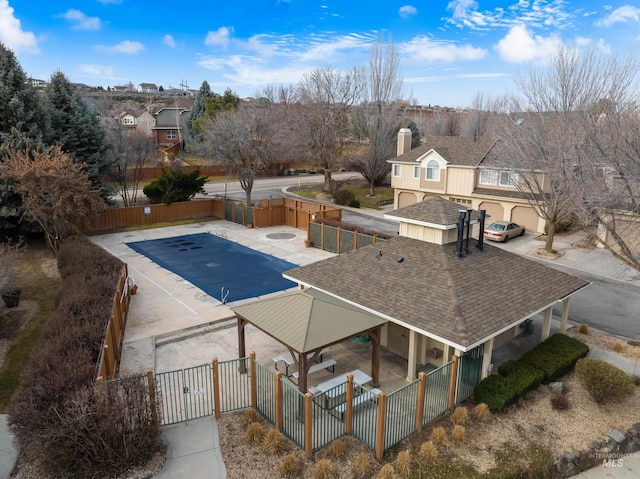 view of pool featuring fence private yard, a gate, and a residential view