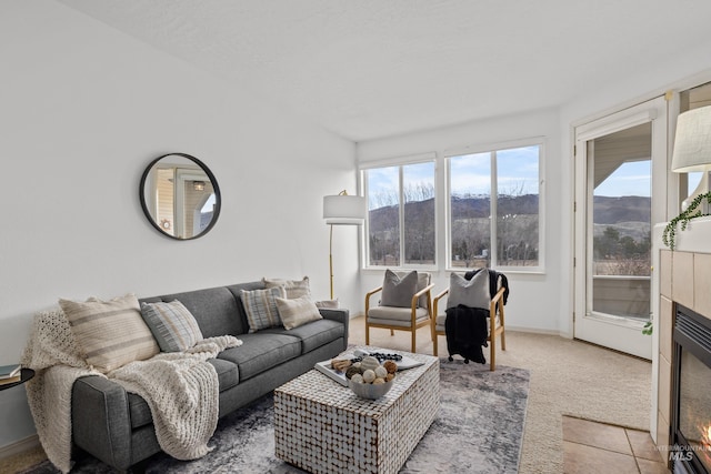 living room featuring light carpet, a mountain view, baseboards, and light tile patterned floors