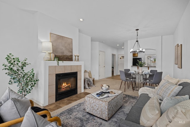 living room featuring a notable chandelier, a tile fireplace, and recessed lighting