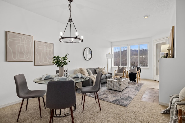 tiled dining space with carpet floors, a notable chandelier, and baseboards