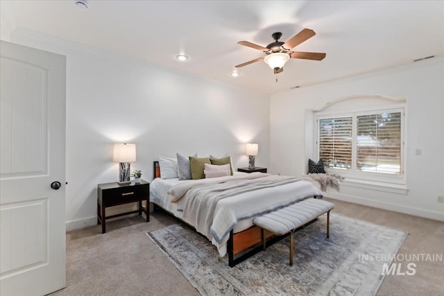 bedroom with visible vents, baseboards, light colored carpet, and a ceiling fan