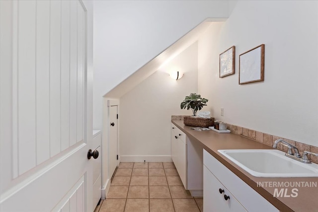 laundry area featuring light tile patterned floors and a sink