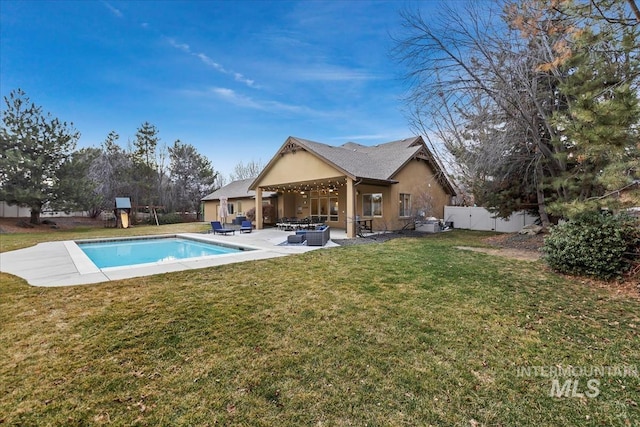 back of house with a patio, a fenced backyard, a yard, outdoor lounge area, and a fenced in pool