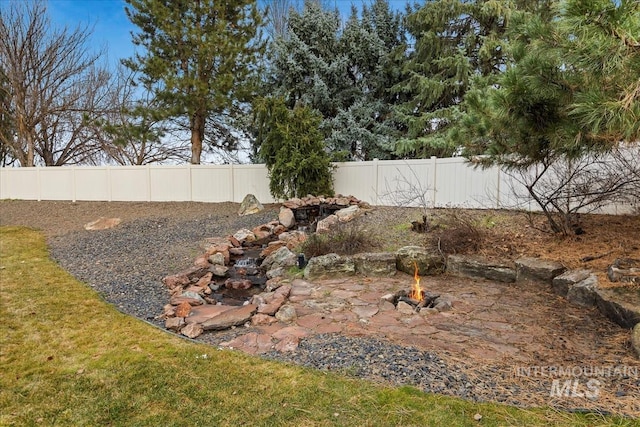 view of yard with a fire pit and a fenced backyard