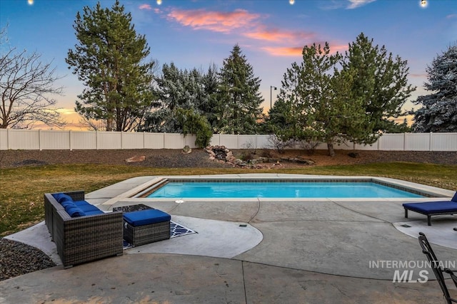 pool at dusk with a fenced in pool, a patio, and a fenced backyard