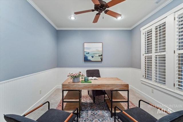 carpeted office with ornamental molding, a ceiling fan, and wainscoting