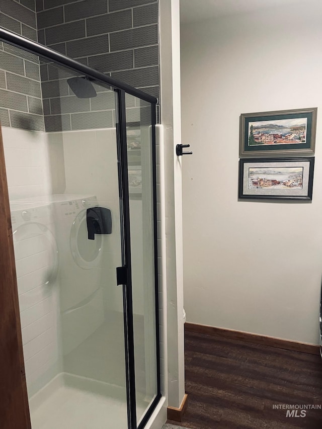 bathroom with wood-type flooring and a shower with shower door