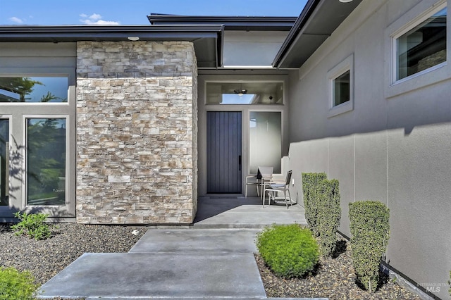 2313 S Aburge Ave, Meridian, ID 83642 - view of exterior entry featuring stone siding, a patio area, and stucco siding
