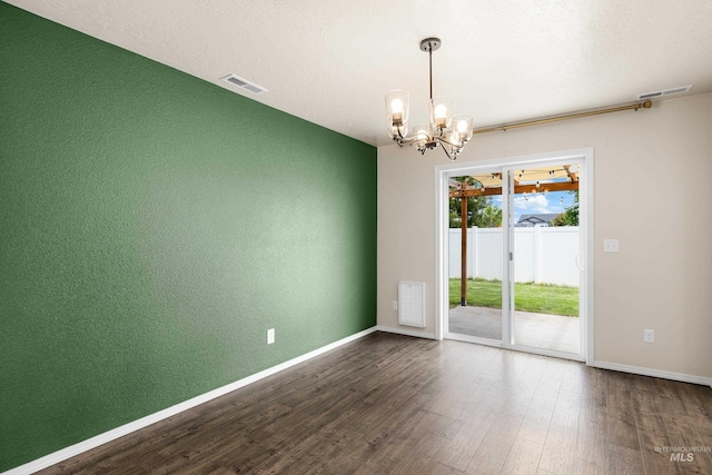 942 S Stibnite Pl, Kuna, ID 83634 - spare room with a chandelier, dark wood-style flooring, baseboards, and a textured wall