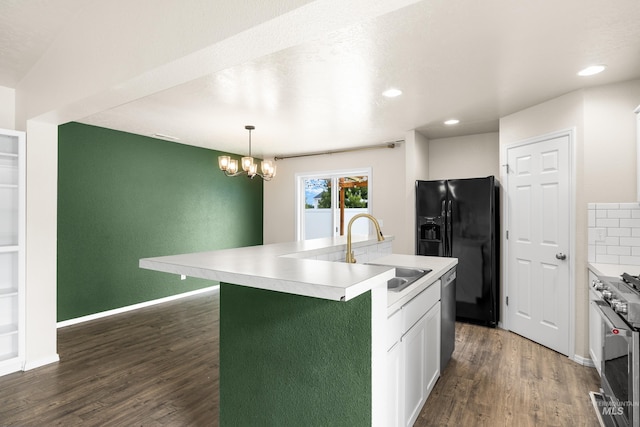 942 S Stibnite Pl, Kuna, ID 83634 - kitchen featuring a sink, appliances with stainless steel finishes, dark wood-style floors, an island with sink, and light countertops