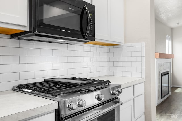 942 S Stibnite Pl, Kuna, ID 83634 - kitchen with stainless steel range with gas stovetop, black microwave, light countertops, and white cabinetry