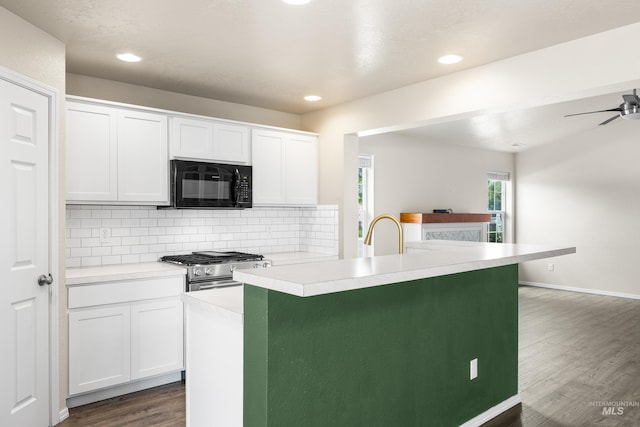 942 S Stibnite Pl, Kuna, ID 83634 - kitchen featuring black microwave, stainless steel gas stove, dark wood-type flooring, light countertops, and tasteful backsplash