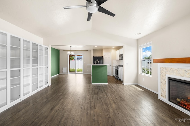 942 S Stibnite Pl, Kuna, ID 83634 - unfurnished living room with a tiled fireplace, a chandelier, vaulted ceiling, dark wood-style floors, and healthy amount of natural light
