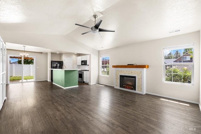 942 S Stibnite Pl, Kuna, ID 83634 - unfurnished living room featuring a chandelier, a fireplace, dark wood finished floors, and vaulted ceiling