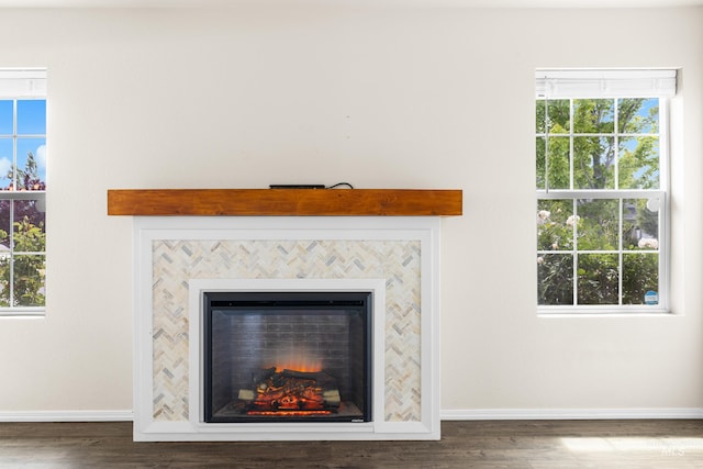 942 S Stibnite Pl, Kuna, ID 83634 - detailed view of baseboards, a tiled fireplace, and wood finished floors