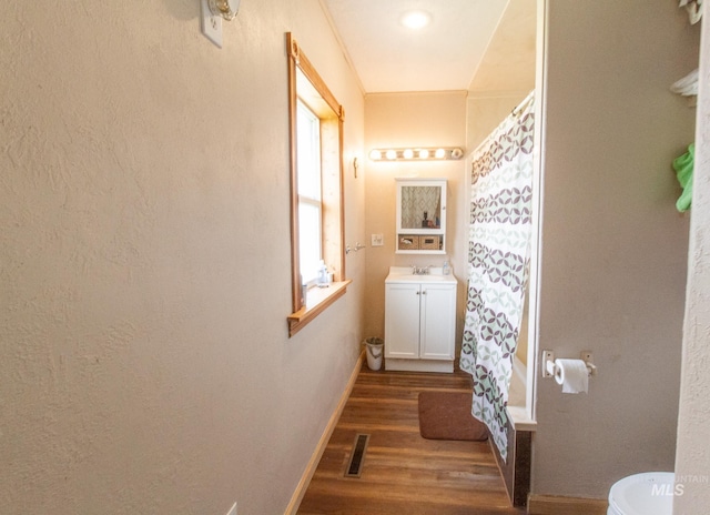 bathroom featuring vanity, hardwood / wood-style floors, curtained shower, and toilet