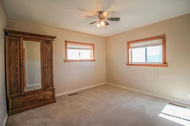 carpeted spare room with ceiling fan and a healthy amount of sunlight