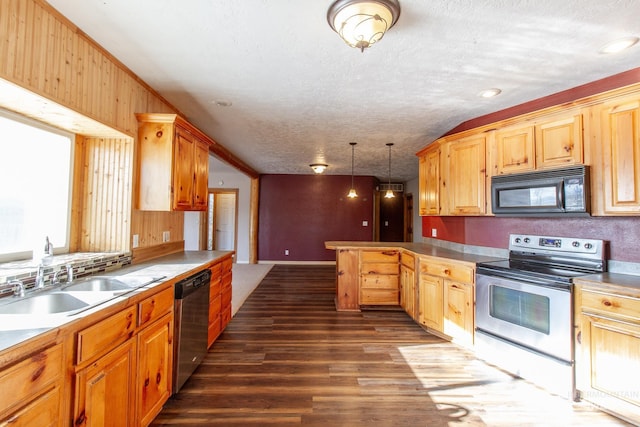 kitchen featuring dark wood-type flooring, sink, decorative light fixtures, a textured ceiling, and stainless steel appliances